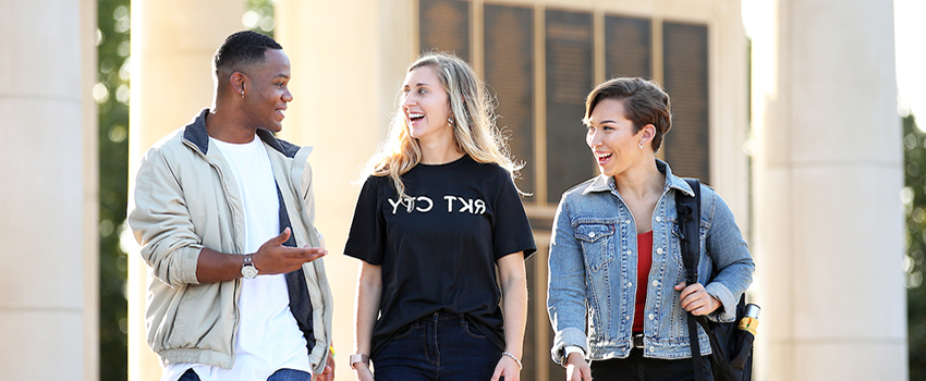 Three students walking and talking outside at South's campus.